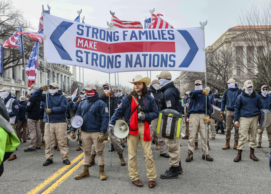 a group of protesters hold a sign that reads “Strong families make strong nations”