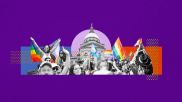 Numerous LGBTQ+ flags and cheerful people in foreground of  the Georgia Capitol building.