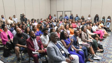 Large group of people seated in conference room.