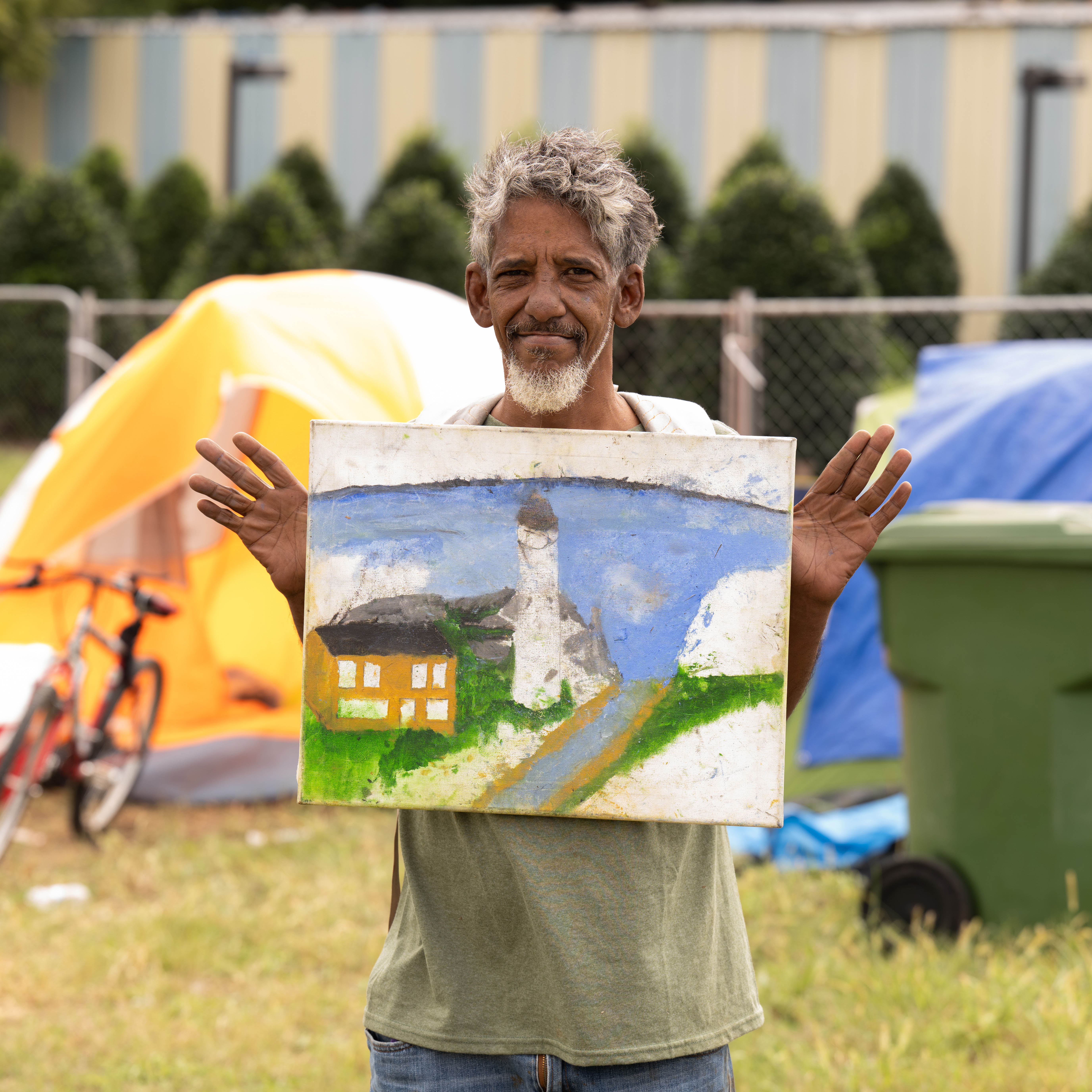 Person holds a painted canvas.